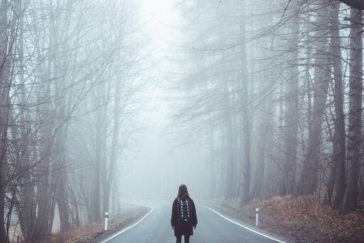girl walking on the road in the woods trying to understand how to know God's will.