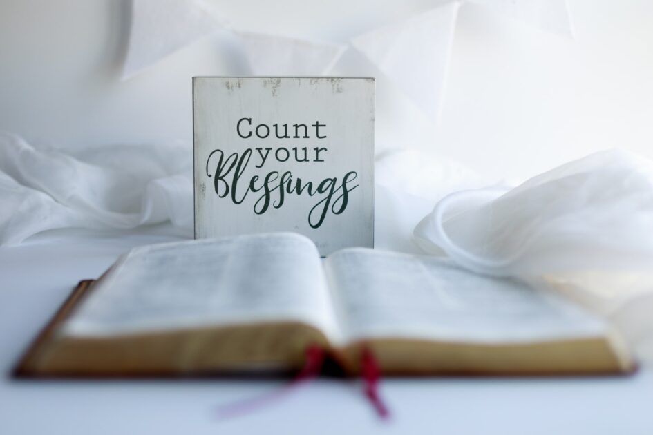 Open bible on a white cloth with an inscription on the background that says "Count your blessings."